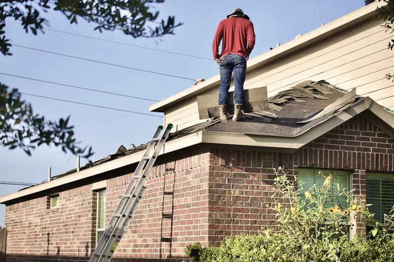 Professional roofer working on a residential roof in Laws